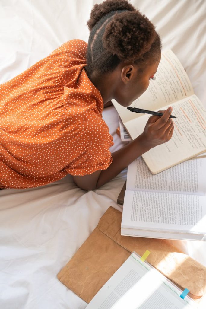 A woman studying and writing in a cozy indoor setting, emphasizing focus and education.